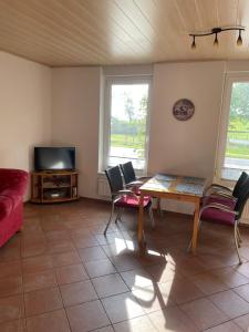 a living room with a table and chairs and a tv at Haus Denker in Brunsbüttel +23 photos