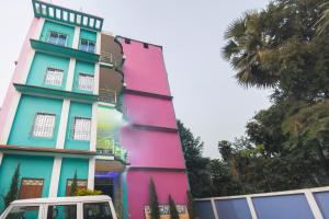 a colorful building with a van parked in front of it at Hotel O Aagman Guest House in Hākala