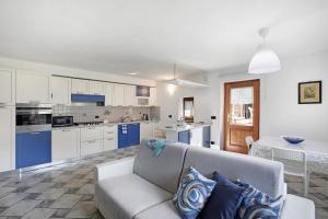 un salon avec un canapé et une cuisine dans l'établissement Casa Sabrina - Appartamento Blu, à Aoste