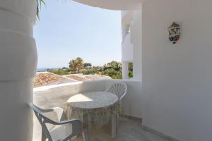 a balcony with a table and chairs and a view of the ocean at Lovely 2 bed apt overlooking golf in Mijas Costa