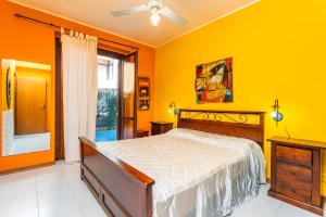 Un dormitorio con una cama y una pared amarilla. en Le Piramidi Seaside House, en Fondachello