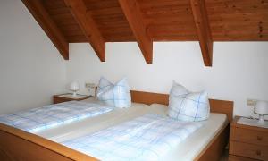Un dormitorio con dos camas con almohadas azules y blancas. en Sommerhof Rauber, en Immenstaad am Bodensee