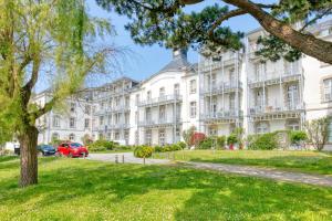 a large white building with a tree in front of it at Appartement piscine et plage 4p 2ét in Le Croisic
