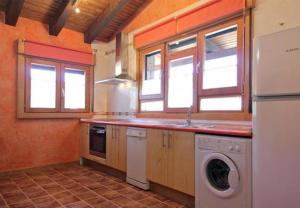 a kitchen with a washer and dryer in it at El Mirador De Campumedra in Vadillo