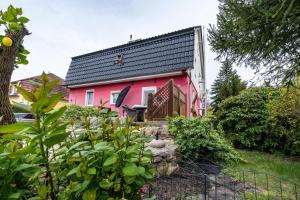 une maison rose avec un toit noir dans l'établissement Urlaub Mit Hund, à Neupetershain