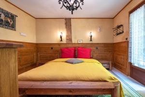 a bedroom with a bed with yellow and red pillows at Daol Grenn in Pluvigner