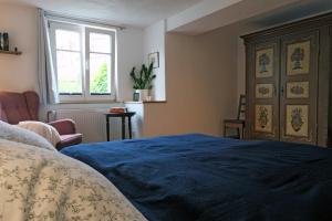 a bedroom with a blue bed and a window at barrierefreie Fewo - 'Im Graben' in Gengenbach