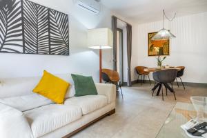 a living room with a white couch and a table at Casale Lorenzo Appartamenti in Orbetello