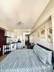 a large bedroom with a bed and a kitchen at Avida Serene Staycation in Davao City