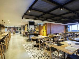 a restaurant with tables and chairs in a room at ibis Styles Bekasi Jatibening in Bekasi