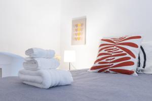 Una pila de toallas encima de una cama. en La Dimora in Città, en Stazione Bari Centrale