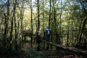 AngoisseにあるLa Cabane Zenの森の橋を渡る男 +2枚の写真