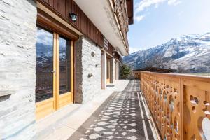 a building with a balcony with a view of mountains at Appartement Albiez Montrond in Albiez-Montrond