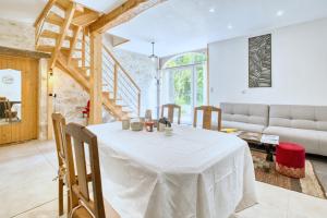 een woonkamer met een tafel en een bank bij Logement Le Buffet De La Gare in Falgueyrat