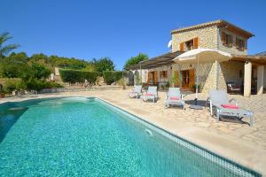 une maison dotée d'une piscine avec des chaises et un parasol dans l'établissement Sa Volta, à Selva
