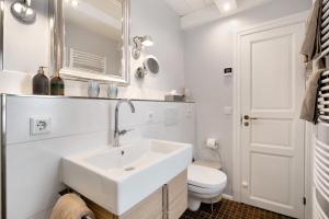 a white bathroom with a sink and a toilet at Hyggelig Am Deich - Ockholm in Ockholm +17 photos