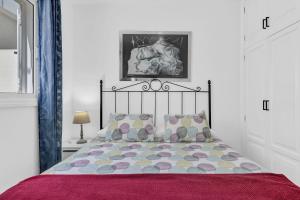 een slaapkamer met een groot bed met een rode deken bij Coqueto y tranquilo Apartamento in Puerto del Carmen