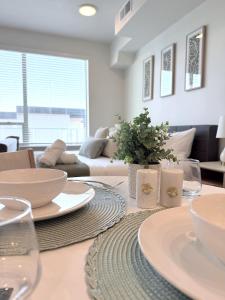 ein Esszimmer mit einem Tisch mit Tellern und Gläsern in der Unterkunft Modern Downtown SLC in Salt Lake City