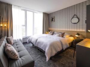 een hotelkamer met een bed en een bank bij ibis Styles Vechta in Vechta