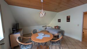 une pièce avec une table, des chaises et un lit dans l'établissement Gerda Ferienwohnung, à Weigendorf