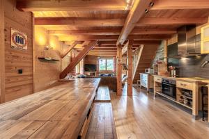 a large kitchen with wooden floors and a long wooden bench at Les Chalets de la Revue in Flumet
