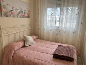 イスラ・クリスティナにあるApartamento El Mirador del Cantilのピンクのソファと窓が備わるベッドルーム1室が備わります。 +29枚の写真