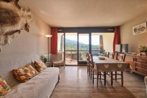 een woonkamer met een bank en een eettafel bij Cosy and nice view on mountains in Villard-de-Lans