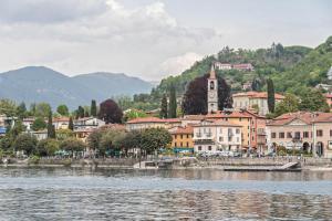 a town next to a body of water with a clock tower at Appartamento Ormeggio Lago Maggiore in Laveno
