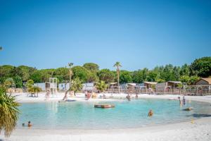 a group of people in a swimming pool on a beach at Camping 5 étoiles Location 6 Pers in Vendres-Plage