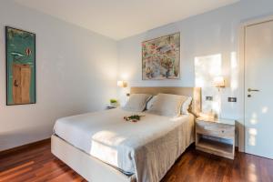 a bedroom with a white bed and a painting on the wall at Casa Ortensia in Malcesine