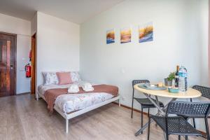 a bedroom with a bed and a table and chairs at Gaivotas House in Alvor