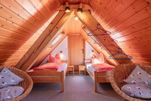 a room with two beds and chairs in a attic at Brosihof in Erlenbach