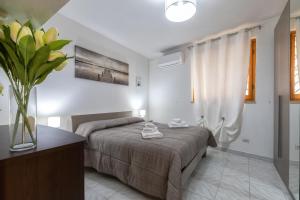 a bedroom with a bed and a vase of flowers at La casetta Bianca in Sassari