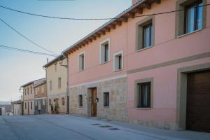 an empty street next to a pink building at Casa Rural El Rincon Del Che in Castrojeriz