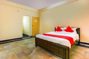 a bedroom with a large bed with red pillows at Hotel O Sai Residency Near SR Nagar metro station in Hyderabad +32 photos