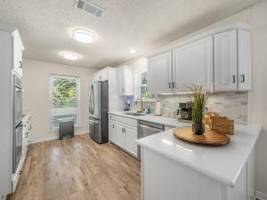 Una cocina con gabinetes blancos y encimera. en Westminster Retreat 2 King Bed, Pool, Game Room, en Richardson