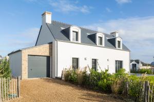une maison blanche avec un toit noir dans l'établissement Ô Vagues de la Torche à 300m plage, à Penmarcʼh