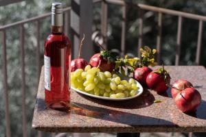 a bottle of wine and a plate of fruit on a table at Krinos apartment 2 in Kharadhiátika