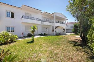 a large white house with a yard at Algarve apartments D in Olhos de Água