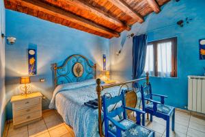 a bedroom with blue walls and a bed with two blue chairs at Il Grappolo E La Rosa in Montefalco +58 photos