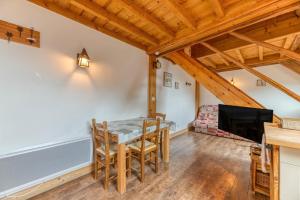 een eetkamer met een tafel en stoelen en een flatscreen-tv bij Auberge Passoud 202 in Oz