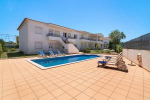 a swimming pool in front of a house at Algarve apartments I in Olhos de Água