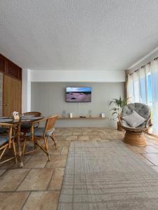 a living room with a table and chairs and a flat screen tv at Mar & Relax, apartamento en primera linea de playa in Porlamar