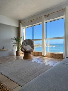 a bedroom with a bed and a large window with the ocean at Mar & Relax, apartamento en primera linea de playa in Porlamar +15 photos