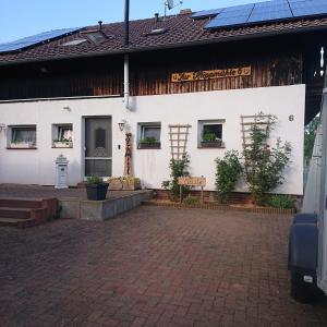 a white building with windows and a brick driveway at Belroki Ranch in Waldeck