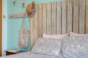 a bed with a wooden headboard and a hat on the wall at Apartamento Bahía Golf Suites in El Puerto de Santa María +22 photos