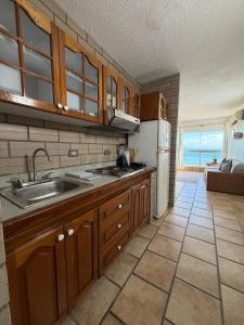 a kitchen with a sink and a refrigerator at Mar & Relax, apartamento en primera linea de playa in Porlamar