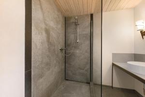 a shower with a glass door in a bathroom at Restaurant Fewo Golsong in Thaleischweiler-Fröschen +68 photos