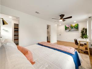Un dormitorio blanco con una cama y un ventilador de techo. en Bellini House Stunning Modern 3bd Home, en Richardson
