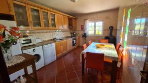 a kitchen with a table and a dining room at Solar Rubina - Piscina Água Salgada in Belmonte